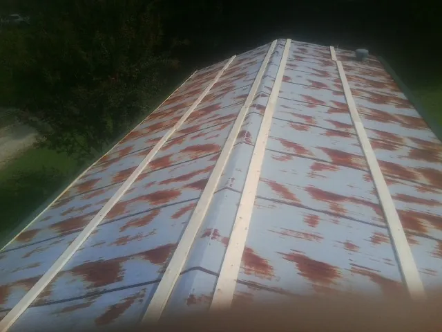 Rusted metal roof panels with new wood purlins before replacement — Storm Damage Roof Repair in Rock City Falls by Roofing Brothers