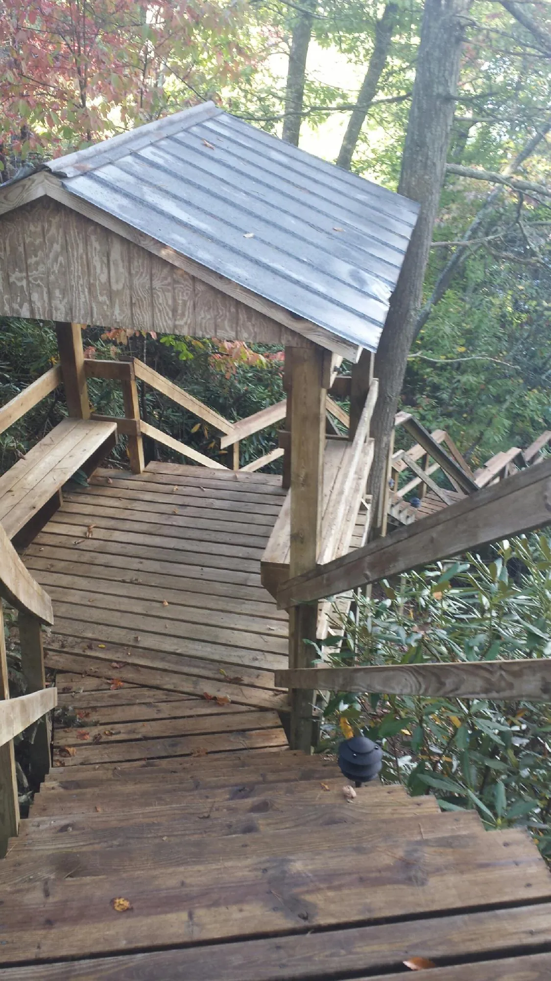 Metal roofed shelter over wooden steps on a wooded walkway — Skylight Repair & Installation work by our crew in Rock City Falls