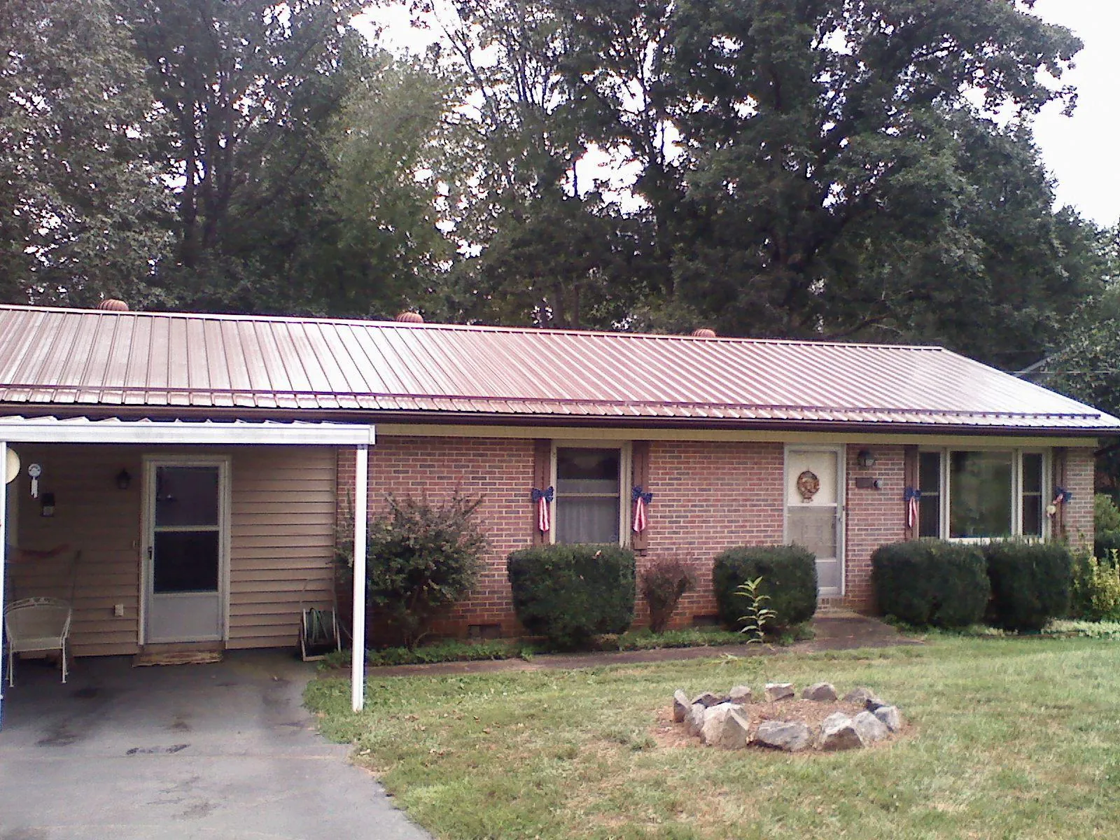 Bronze metal roof and carport on a brick ranch home — Roof Repair work by our crew in Rock City Falls